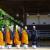 Monks in orange robes lined up to pray outside wooden temple