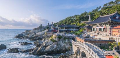 Ornate temple buildings and bridge on the coast with breaking waves