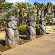 Three large rock statues with faces in park