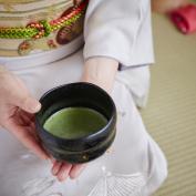 Hands holding cup of green tea