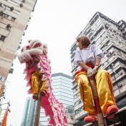 Ladies perched on top of stilts in dragon costume for Chinese New Year celebrations