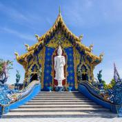 Blue Temple with white Buddha statue at top of stairs