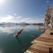 Man diving into lagoon from boardwalk in Khao Sok
