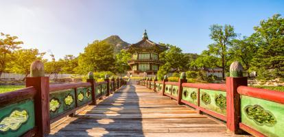 Ornate bridge leading to small pagoda in park