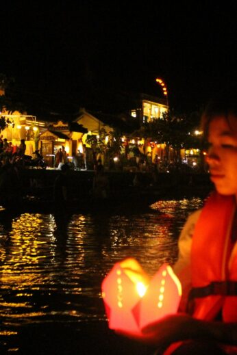Setting lanterns adrift as we float along the Thu Bon River