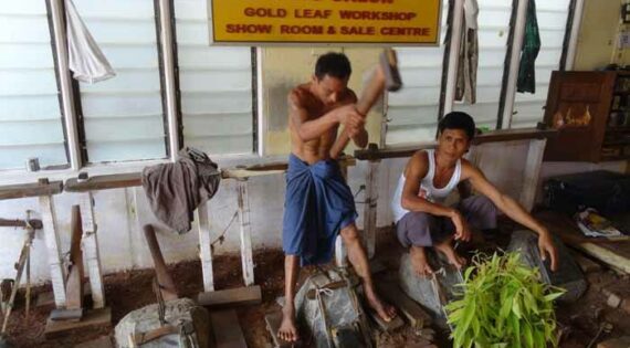 Workers hammering out gold leaf in Mandalay