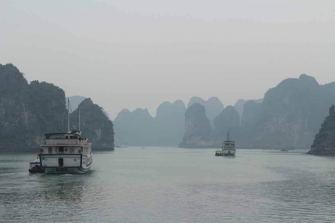 Boats disappear into the mist on Halong Bay