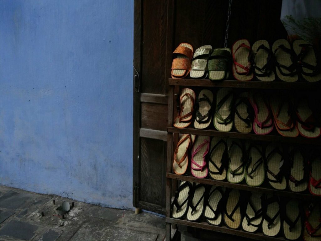 Racks of shoes in a colourful hallway in Vietnam