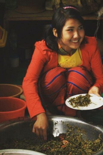 Girl eating lahpet in Pindaya, Burma
