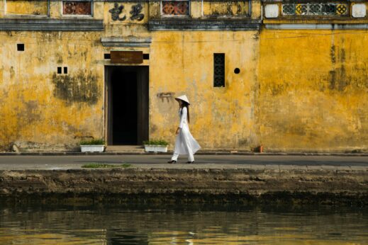 hoi an yellow wall woman walking vietnam