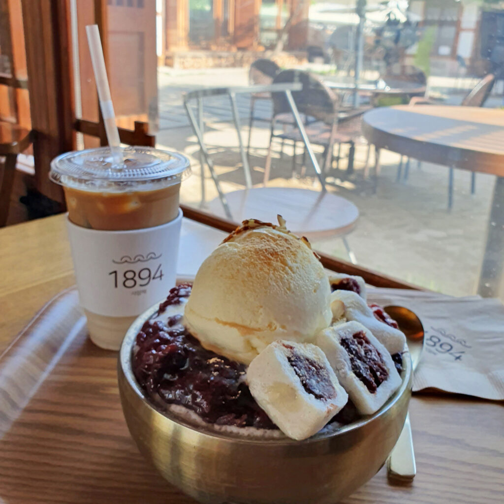 A Korean dessert with ice cream and sweets, with an iced coffee next to it