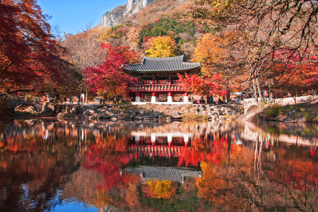 Baegyangsa temple surrounded by autumn colors are reflected on a pond