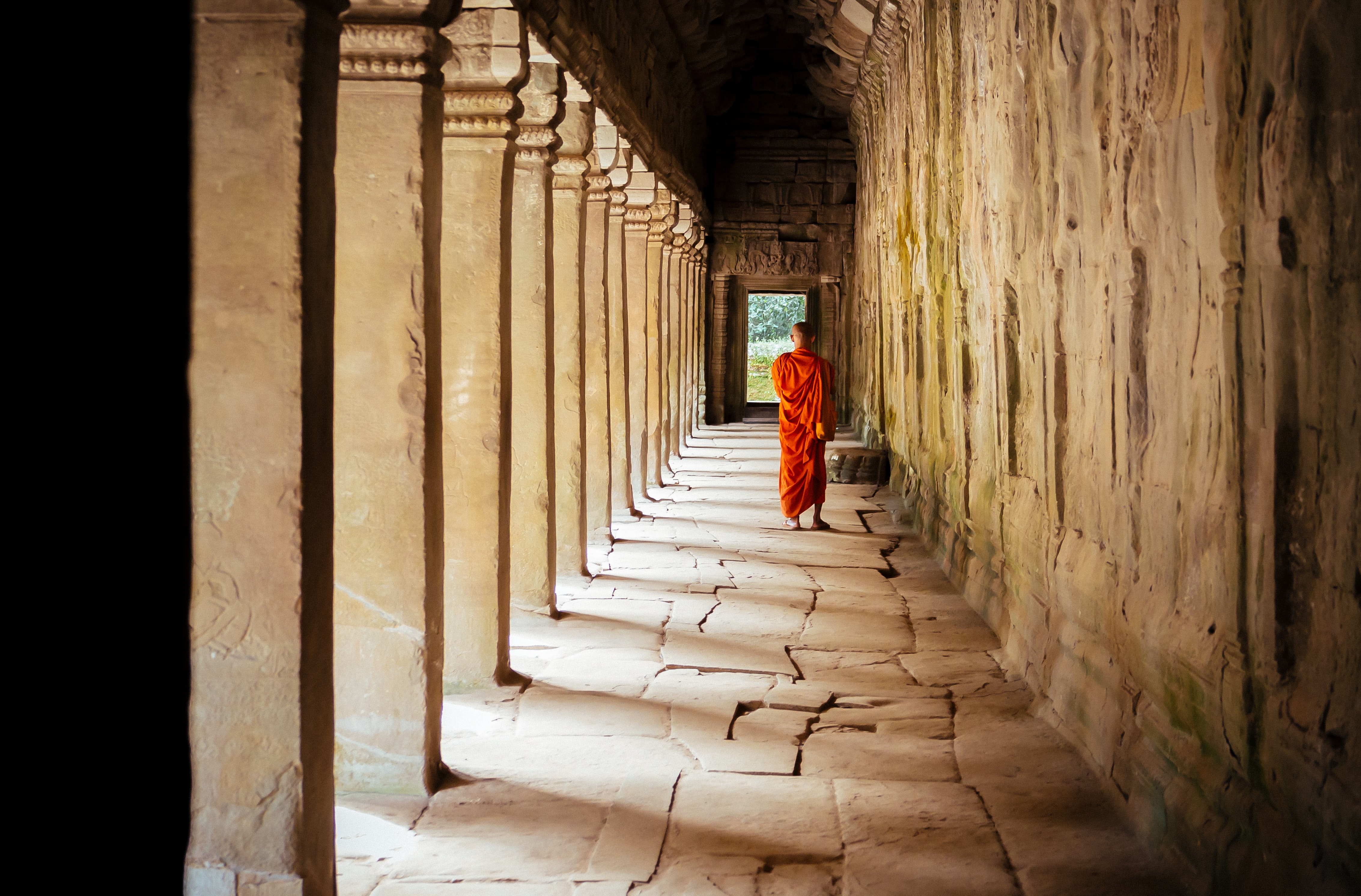 Monk walking under temple arches