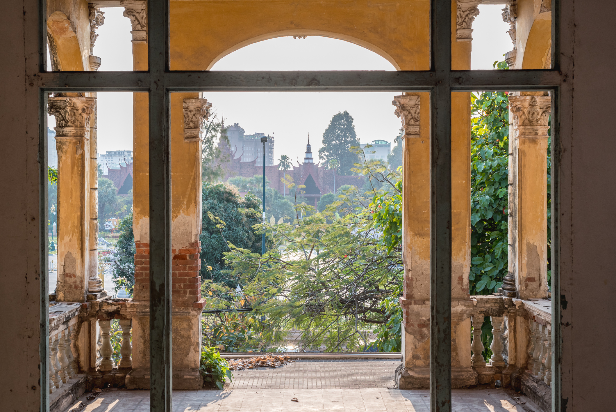 View-of-Phnom-Penh-Royal-Palace-Hero.jpg An old brick archway partially painted provides beautiful views of royal palance in Phnom Penh