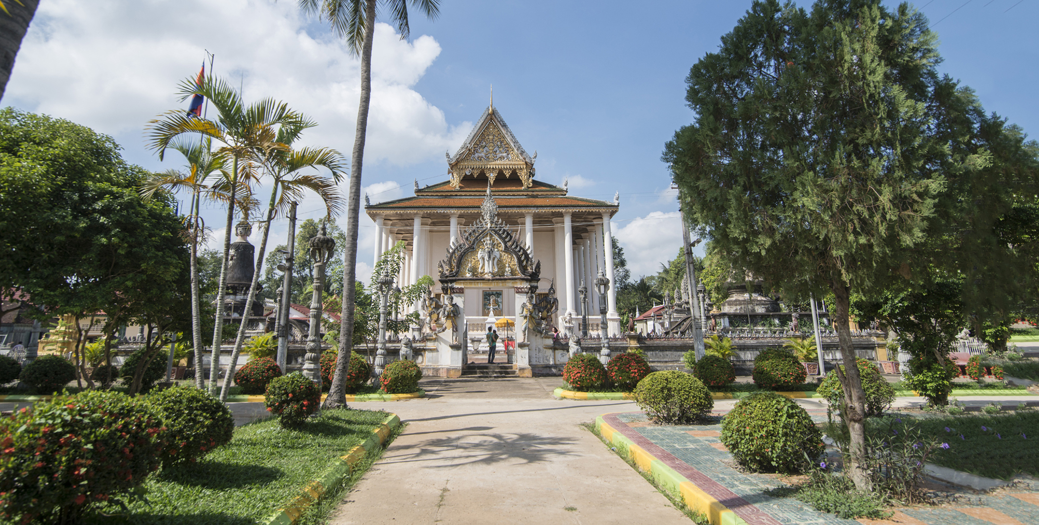 Battambang_Temple_Urf_Hero_B White buddhist temple with golden roof is surrounded by beautiful gardens in Battambang.