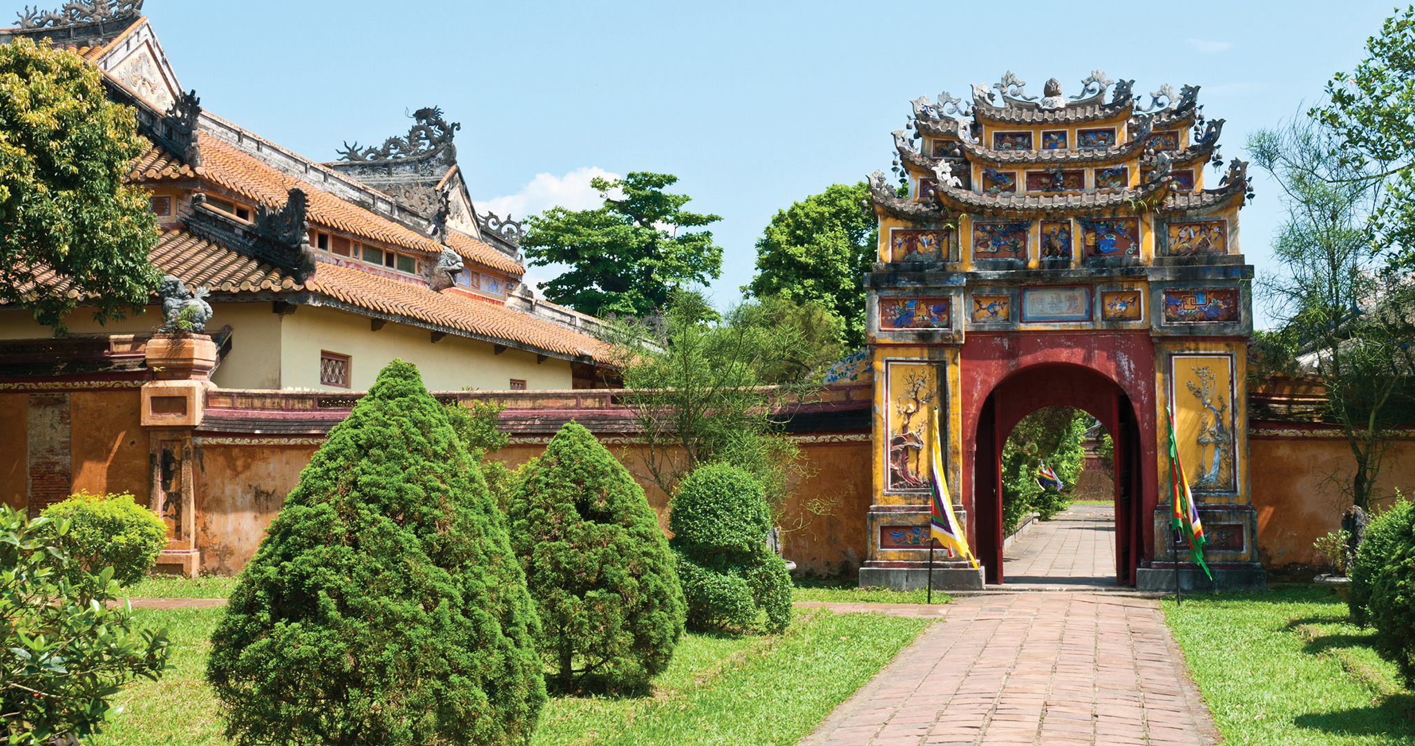 Hue_Vietnam_Borman_Blaikie_Hero Coloured gate surrounded by an orange wall and gardens is the entry point to Hung To Temple in Hue's imperial city, Vietnam