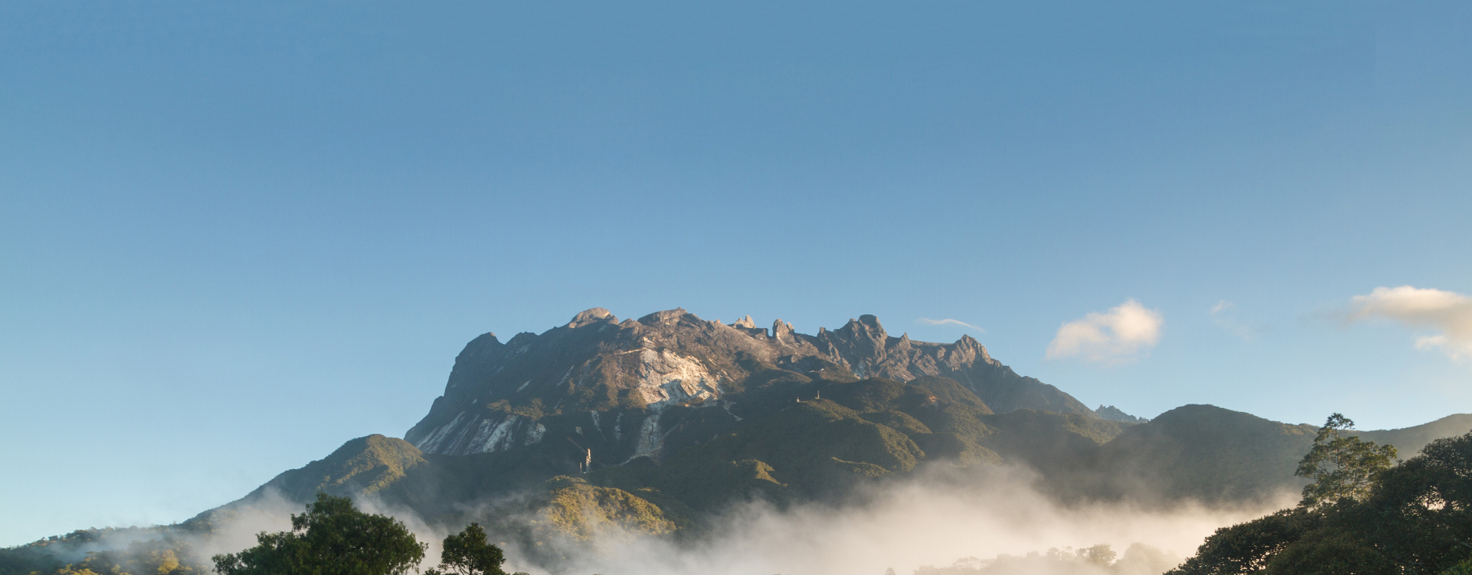 Kinabalu-mountain-iStock-Stephane-Noiret-Hero.jpg Morning light on the dramatic snowed peak of Mount Kinabalu, surrounded by lush jungle