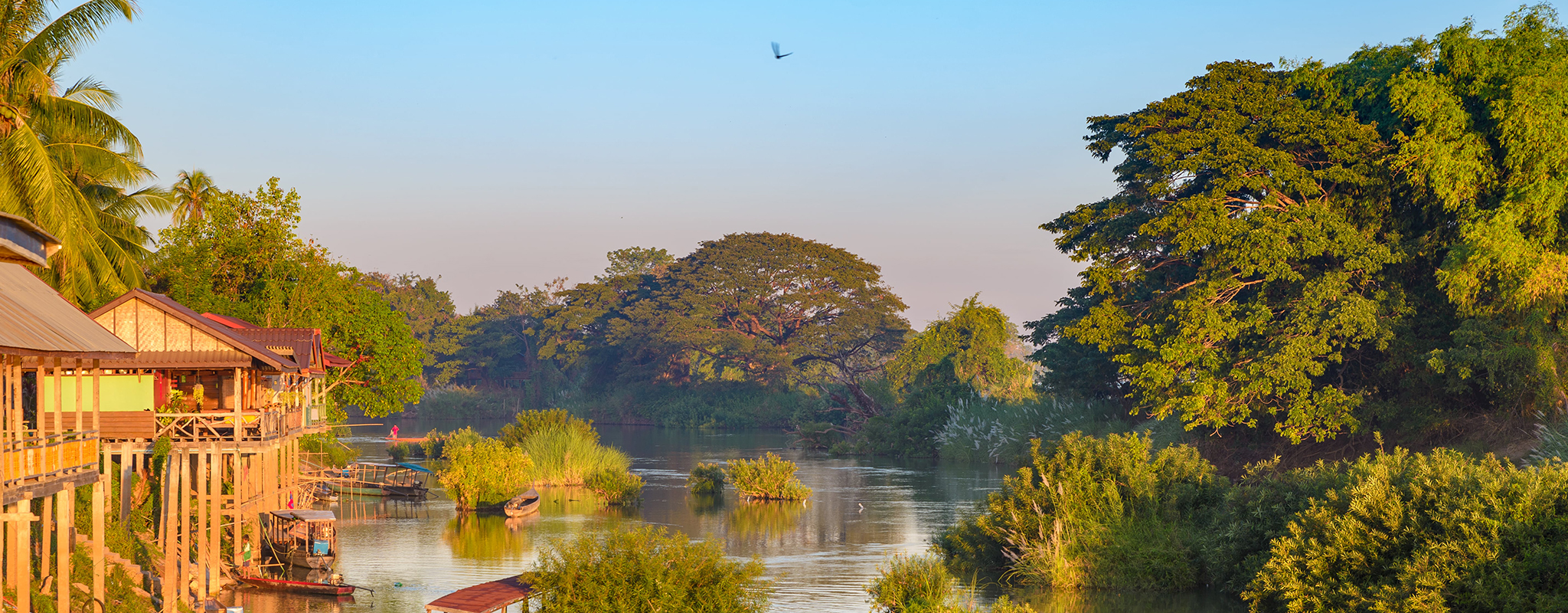 Laos-4000-islands-iStock-Hero.jpg Early morning illuminates riverside houses and boats in Si Phan Don, the 4000 islands of Laos