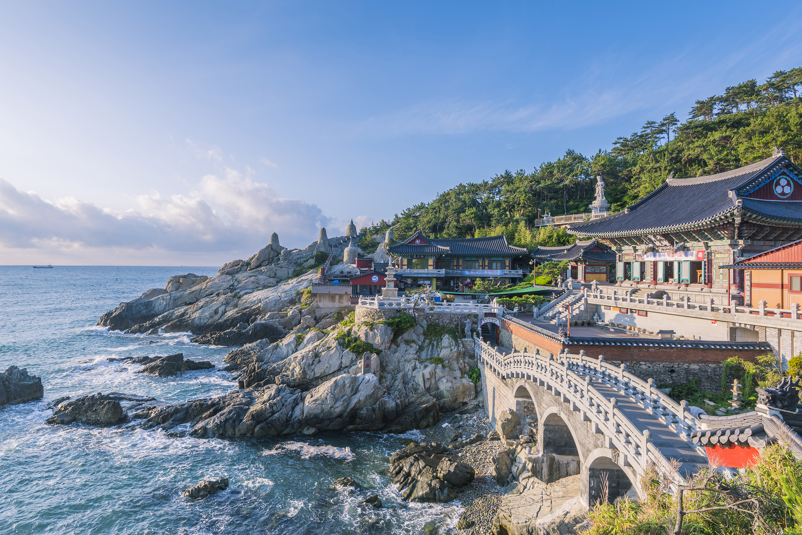 Busan-Haeddong-Yonggunsa-temple.jpg Ornate temple buildings and bridge on the coast with breaking waves