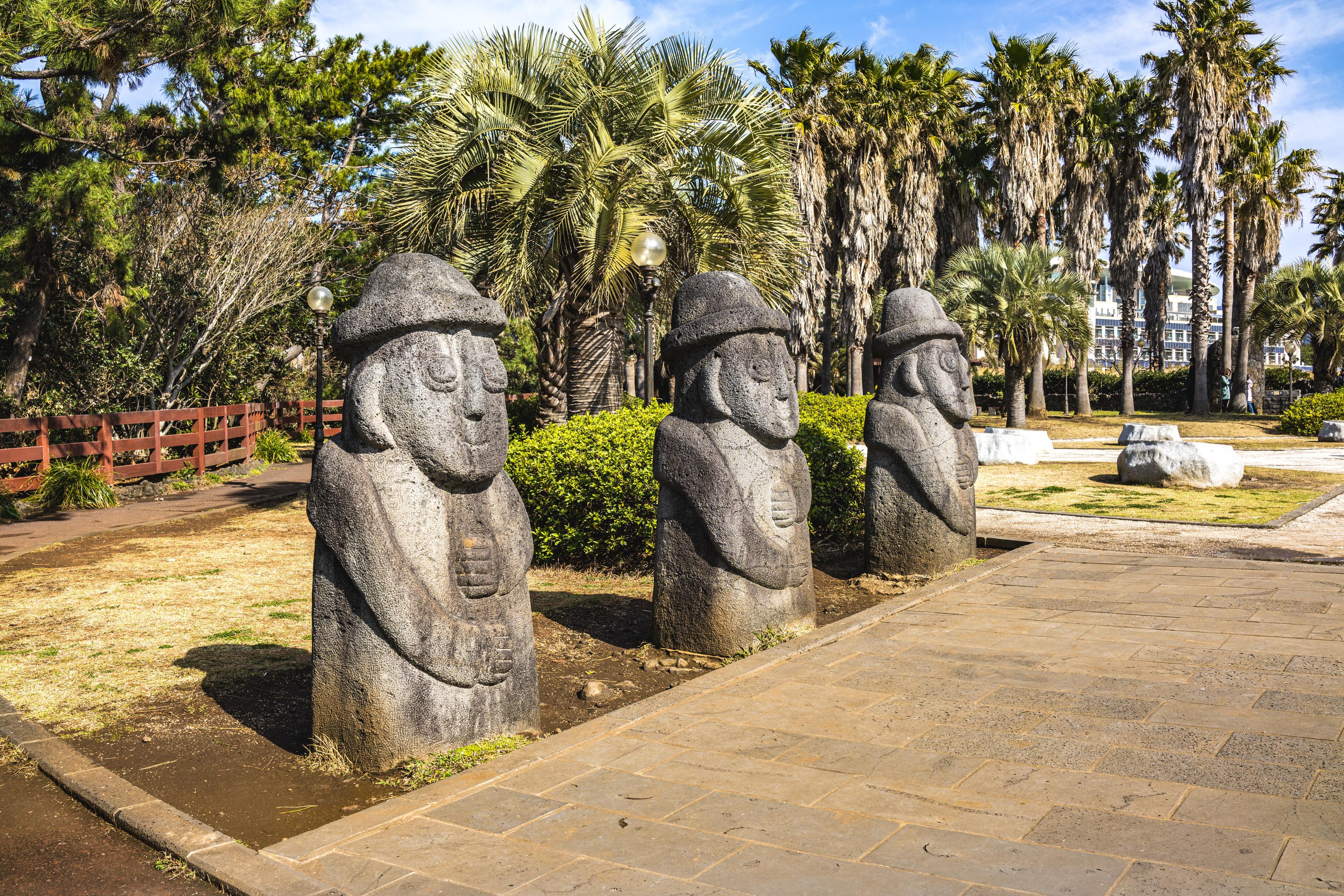 Dol-Hareubangs-statues-Jeju-Island.jpg Three large rock statues with faces in park