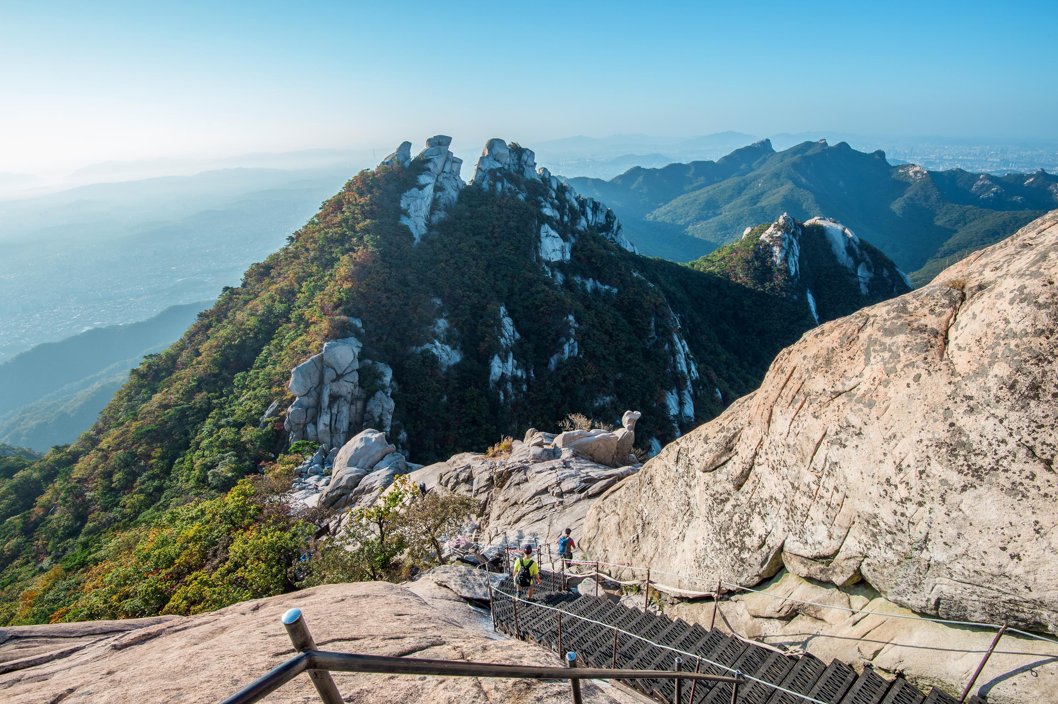 Hikers descending on steps on peak in Bukhansan National Park