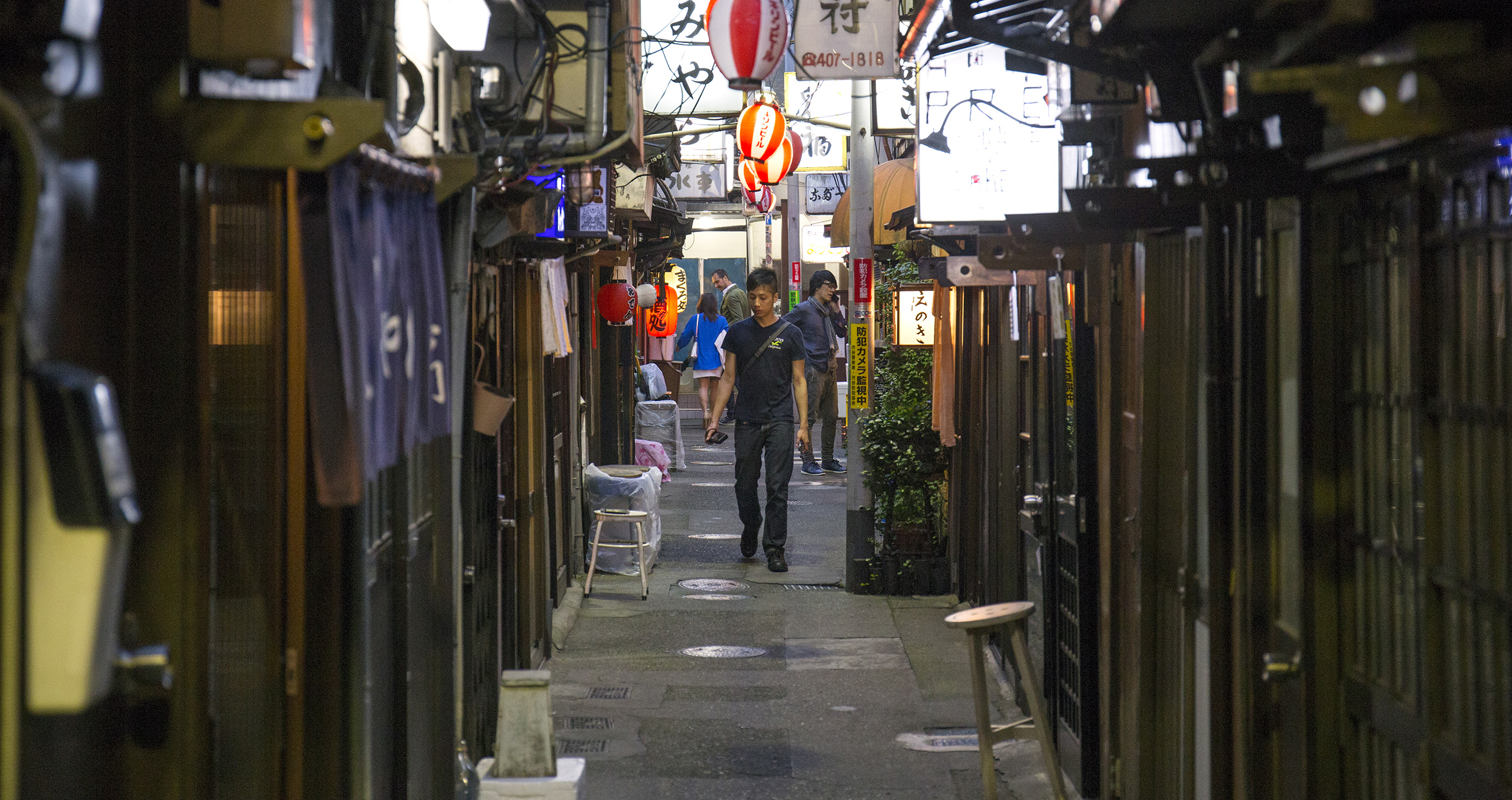 nonbei-yokocho-izakayas-shibuya A man walks in a side street contemplating a number of different izakaya establishments in Shibuya, Tokyo