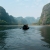 A longboat paddling through karst landscape in Ninh Binh in Vietnam