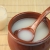 Creamy white Makgeolli rice wine in brown cup with spoon