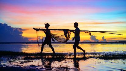 Carrying in the fishing nets at sunset