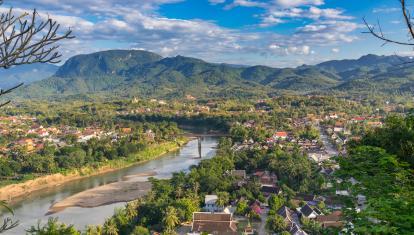 Aerial view of beautiful Luang Prabang city surrounded by jungle and sprawling alongside Nam Khan River