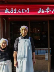 A mother and son stood in front of their family sweet shop in Japan