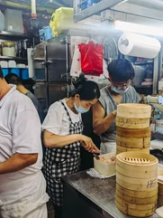 People making dumplings in a hawker market in China town Singapore