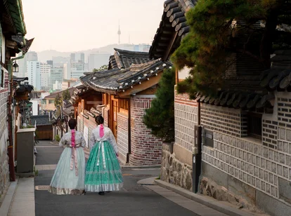 Two ladies wearing traditional Korean dress walking down street in Seoul 