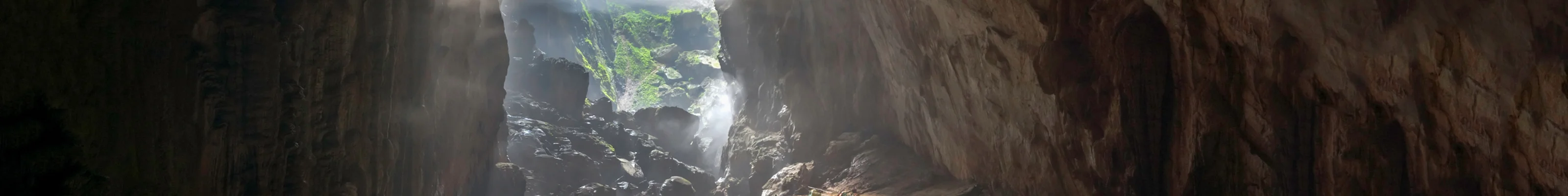 Mist gently covers individual tents lined up in massive cave entrance in Son Doong, Phong Nha