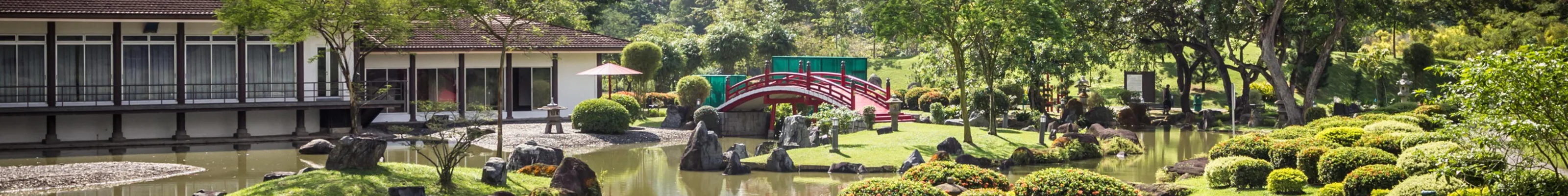 Red bridge over ornamental lake in Chinese and Japanese Gardens in Singapore 