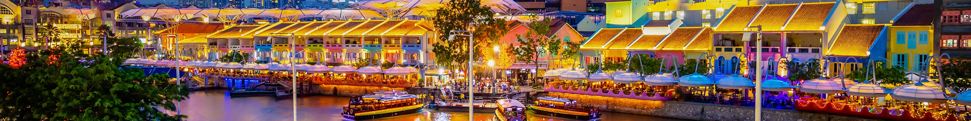 The night lights with vibrant colors in Singapore's Clarke Quay area, with passersby enjoying the riverside walk