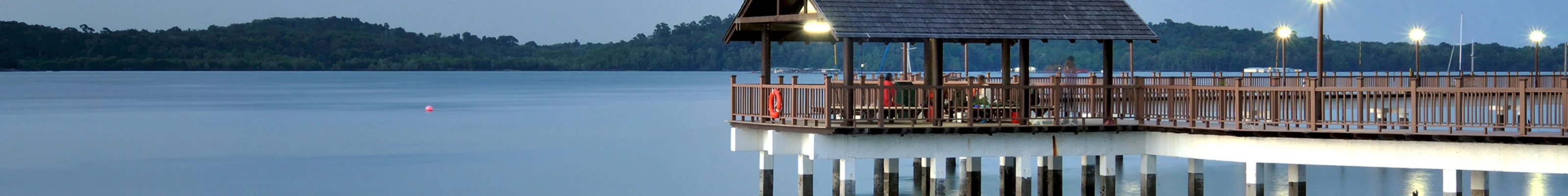 Evening reflections of jetty over lake at Changi, with gentle clouds in the sky