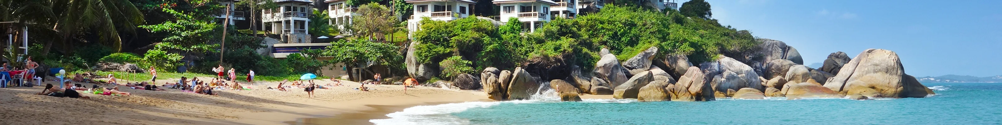 White bungalows in the jungle line Coral Cove beach in Koh Samui, Thailand