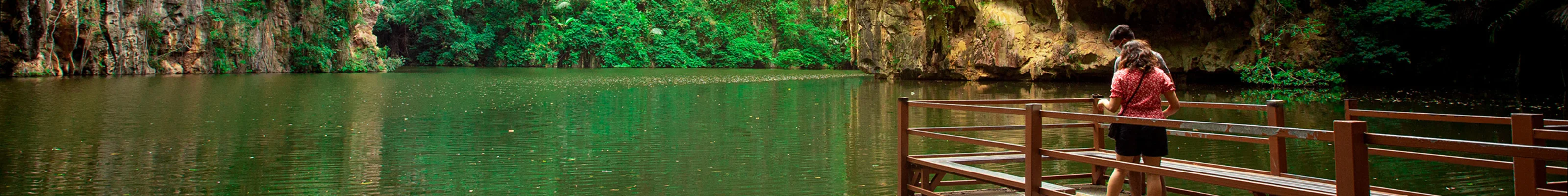 Two tourists admire the tranquil waters of Mirror Lake in Ipoh, Malaysia