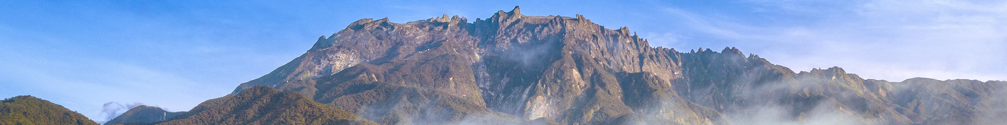 Morning on the dramatic peak of Mount Kinabalu, surrounded by clouds and lush jungle
