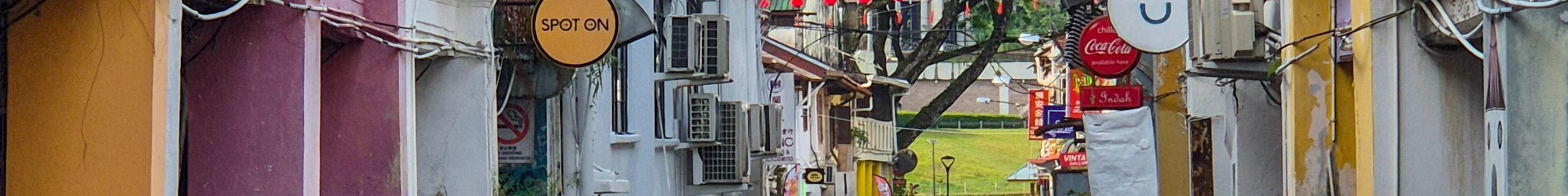 A colourful street in Kuching with a temple in the background