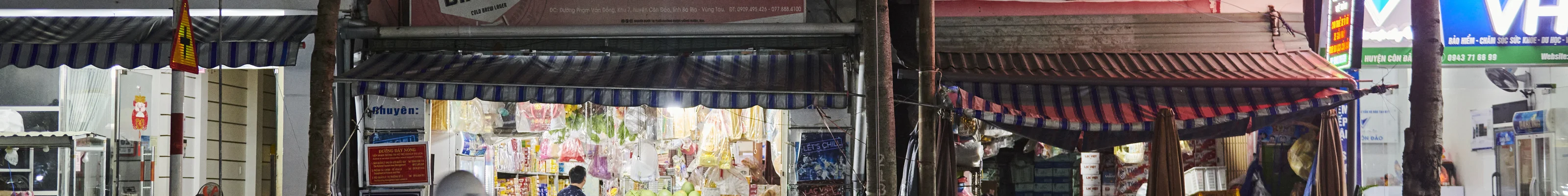 A motorbike whizzing past traditional market stalls in Hanoi, Vietnam
