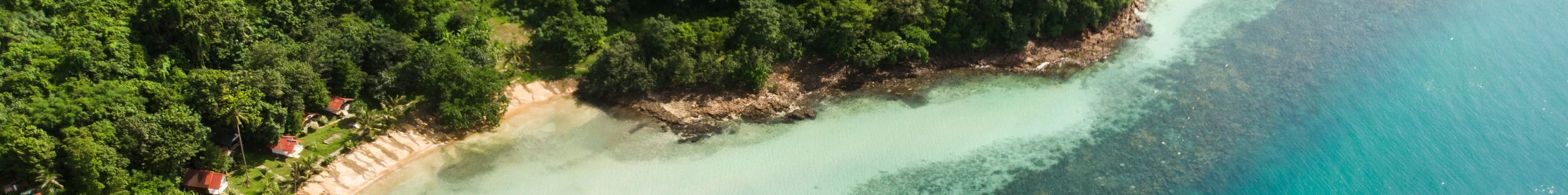 Aerial view of a secluded beach in Ko Chang with crystal clear blue water and jungle