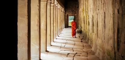 Monk walking under temple arches