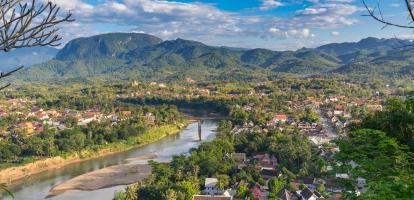 Aerial view of beautiful Luang Prabang city surrounded by jungle and sprawling alongside Nam Khan River