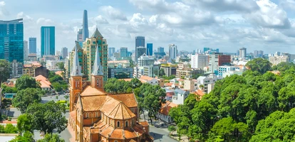Aerial view of Ho Chi Minh City cathedral, with motorcyclists riding on the streets around it