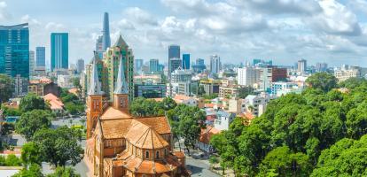 Aerial view of Ho Chi Minh City cathedral, with motorcyclists riding on the streets around it