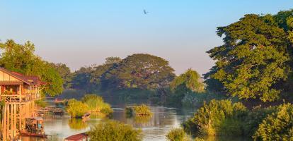 Early morning illuminates riverside houses and boats in Si Phan Don, the 4000 islands of Laos