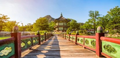 Ornate bridge leading to small pagoda in park
