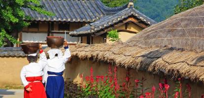 People in traditional dress walking through Hahoe Folk Village